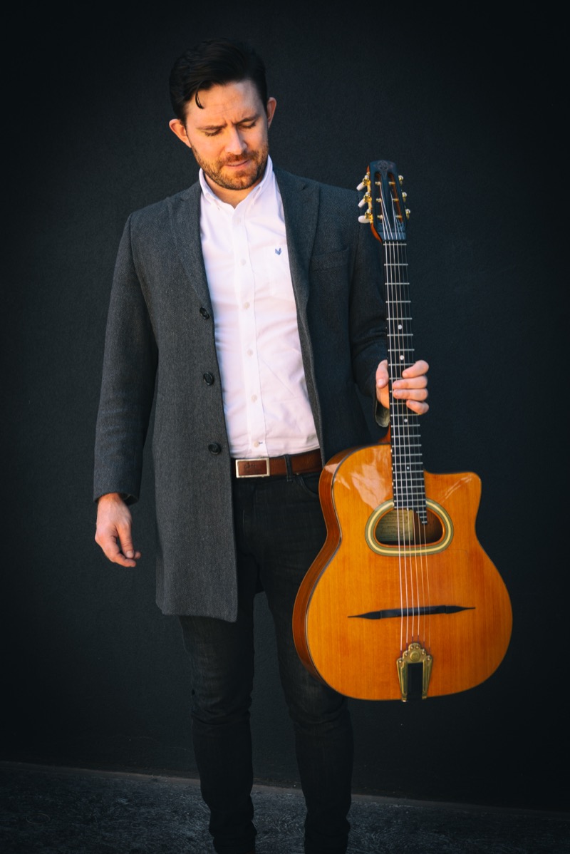 Sam O'Halloran holding his jazz guitar
